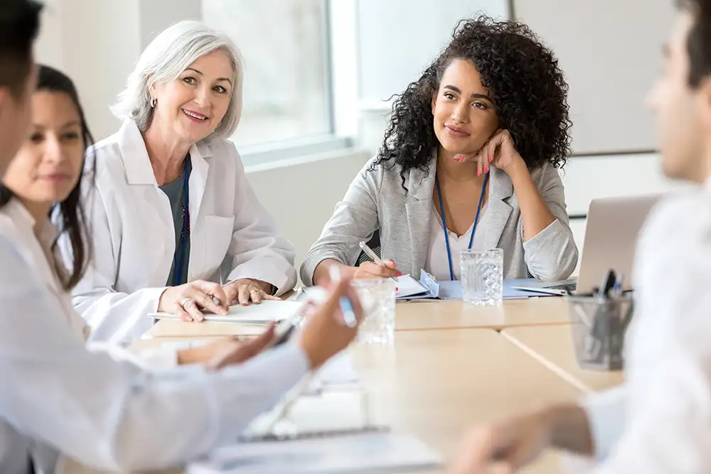 A group of happy looking female physicians sitting at a table